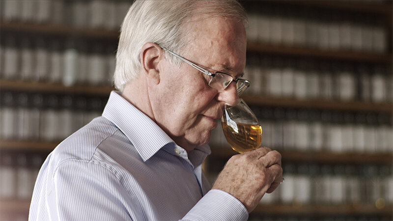 A distiller is using their nose to check whether the whisky has matured properly.